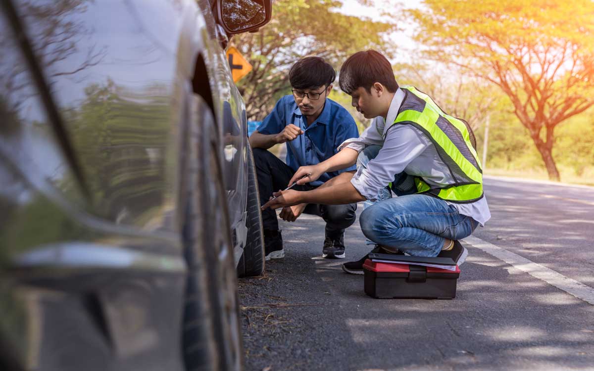 Man fixing Car with Roadside Assistance