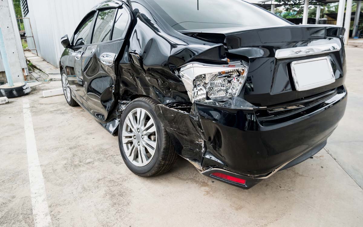 Black car with damaged rear bumper and wheel